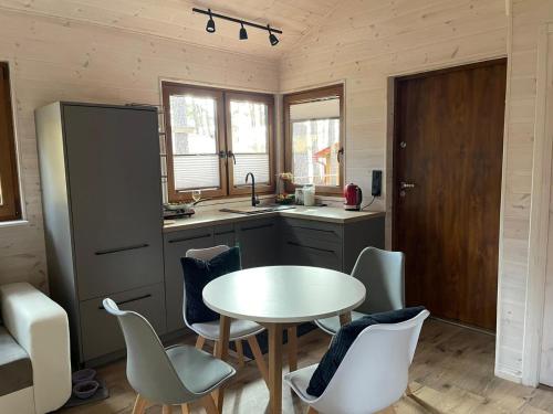 a kitchen with a table and chairs in a room at Oslo N°29 Domek Letniskowy in Borsk