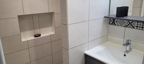a white bathroom with a sink and a mirror at Ferme Peyroutet in Asson