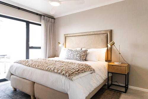 um quarto com uma cama grande e uma janela em Santos Seaview Apartment em Mossel Bay