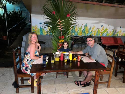 a family sitting at a table in a restaurant at Corcovado Adventures in Drake