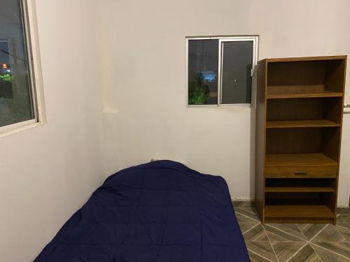 Habitación con cama y estante para libros en Los Arcos Terraza Suites, en Hermosillo