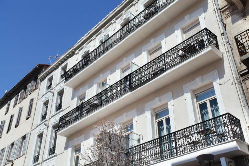 a white building with balconies on the side of it at Hôtel La Villa Tosca in Cannes