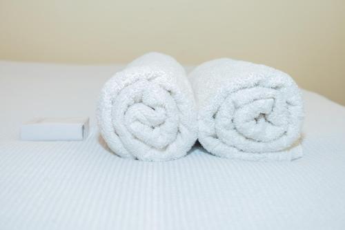 a pair of towels sitting on top of a bed at The Stay Comfort in Nyeri