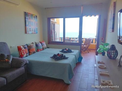 uma sala de estar com uma cama e um sofá em Sea View Playa Arena by HelloApartments em Puerto de Santiago
