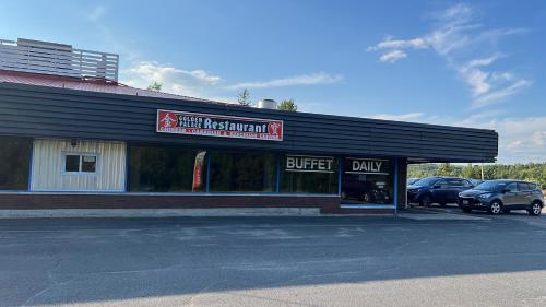a store with cars parked in a parking lot at Lively Inn and Suites - Sudbury in Naughton
