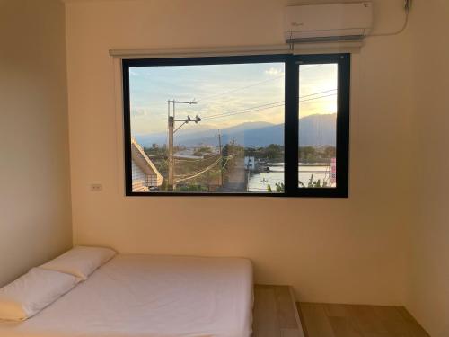 um quarto com uma janela com uma cama em Tino House 全新開幕 質感包棟民宿 em Yilan City
