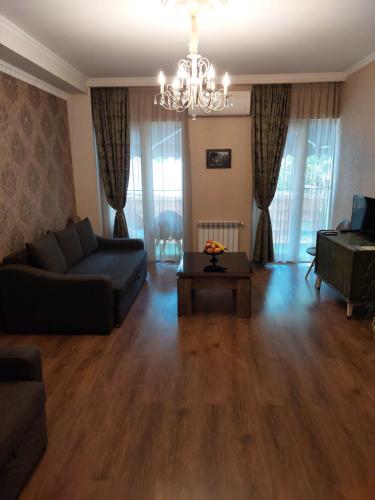 ein Wohnzimmer mit einem Sofa und einem Tisch in der Unterkunft SALOUNIQUE Lux Apartment in Tbilisi City