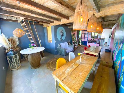 a living room with wooden tables and chairs at Hostel Villa Cacau Trancoso in Trancoso