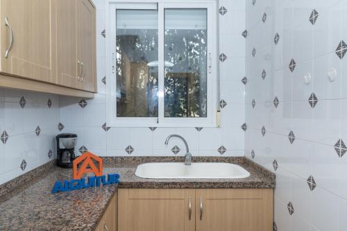 a kitchen with a sink and a window at Pleno Sol, 45 in Cullera