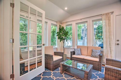 a screened in porch with wicker furniture and windows at 1 Mi to Beach Home with Deck and BBQ in East Falmouth in East Falmouth
