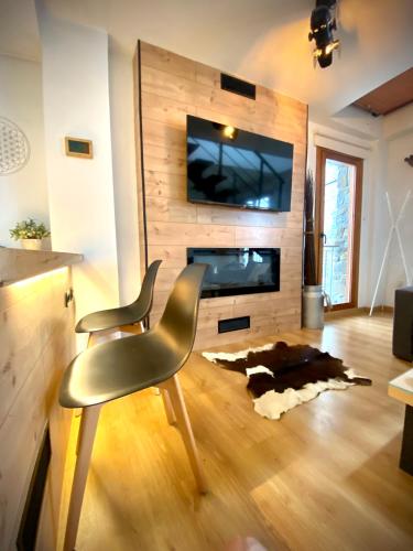 a living room with a table and two chairs and a fireplace at CAL DOMÈNEC RIALP - Dúplex con encanto - Se admiten mascotas in Rialp
