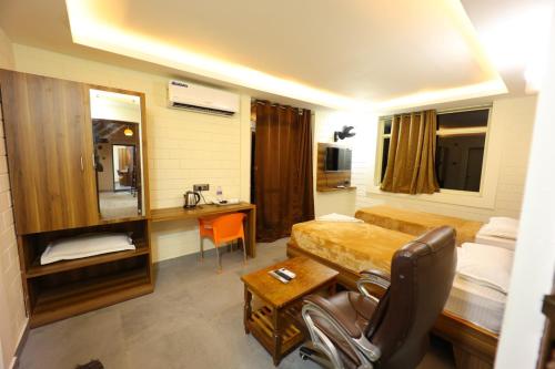 ein Hotelzimmer mit einem Bett und einem Schreibtisch mit einem Stuhl in der Unterkunft Krish Garden in Chidambaram