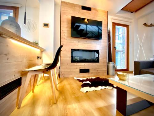 a living room with a tv on a wall at CAL DOMÈNEC RIALP - Dúplex con encanto - Se admiten mascotas in Rialp