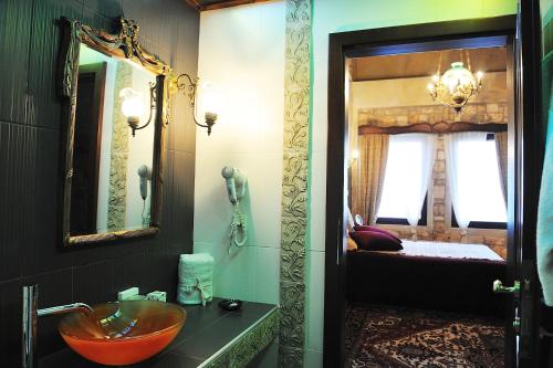 a bathroom with a sink and a mirror at Leventis Art Suites in Panayítsa