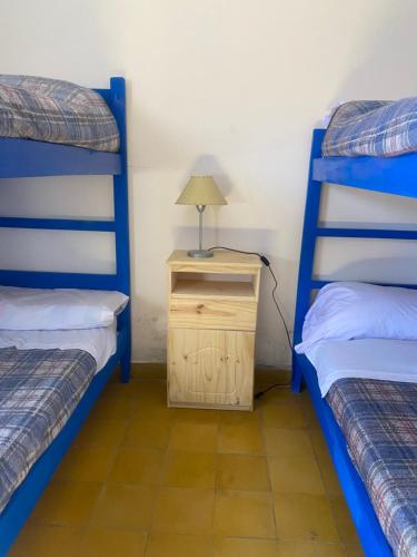 a bedroom with two bunk beds and a lamp on a night stand at El Convento de Tilcara in Tilcara