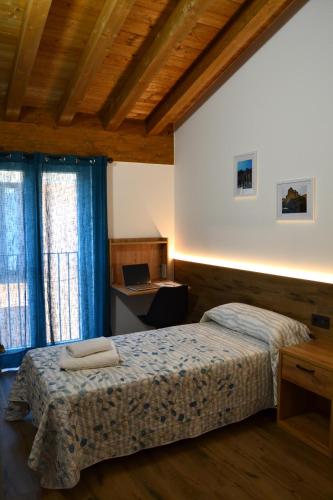 a bedroom with a bed and a desk with a laptop at Apartamento El Mirador de la Rua in Estella