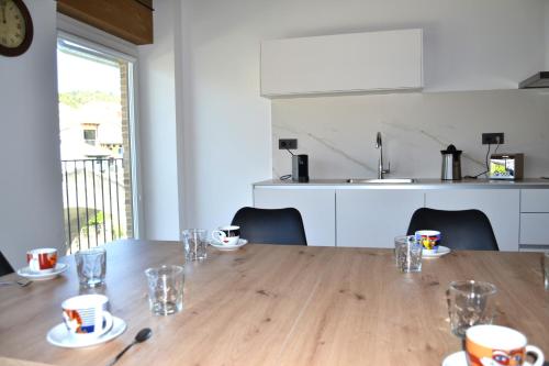 a dining room table with cups and glasses on it at Apartamento El Mirador de la Rua in Estella