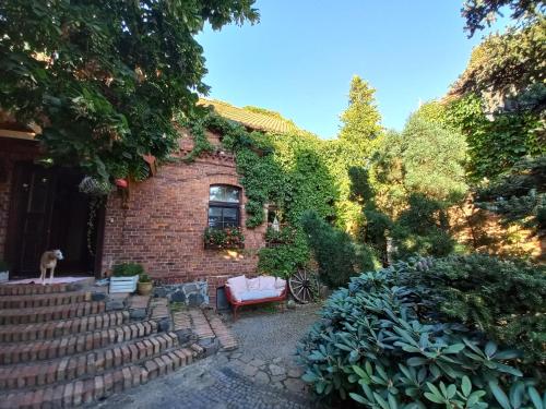 a brick house with a dog sitting in the yard at Avalon Połchowo in Kamień Pomorski
