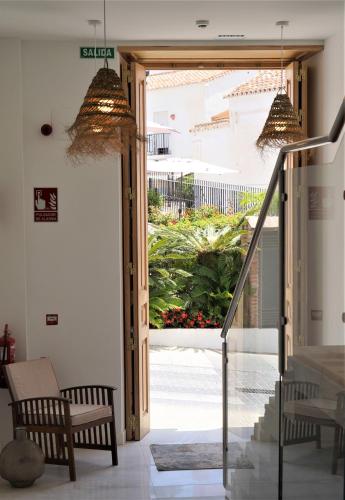 a hallway with a door open to a courtyard with plants at OPUNTIA Hotel Boutique in Mijas