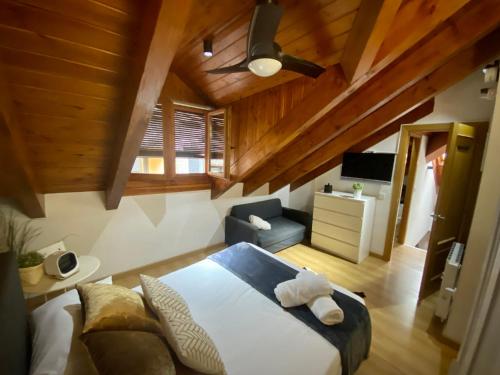 a bedroom with a bed and a chair and a ceiling at CAL DOMÈNEC RIALP - Dúplex con encanto - Se admiten mascotas in Rialp