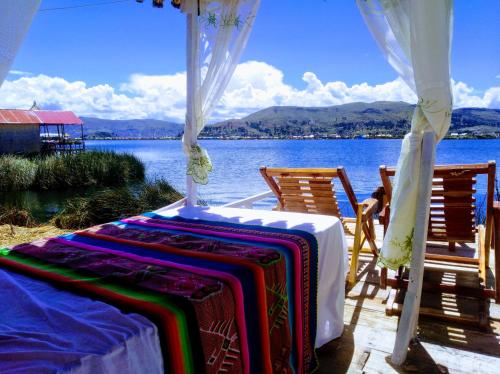 a table and chairs with a view of the water at Titicaca wasy lodge in Puno