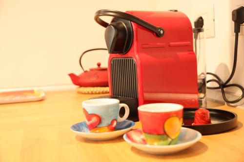 a red coffee maker and two cups on a table at Magnolia Lake Como city center Free Parking in Como