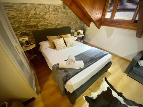 a bedroom with a bed with a hat on it at CAL DOMÈNEC RIALP - Dúplex con encanto - Se admiten mascotas in Rialp