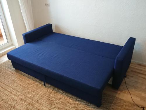 a blue bed in the corner of a room at Õdus korter roheluses - A cozy apartment in a greenery - contactless check-in in Põlva