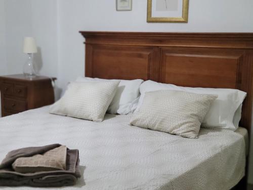 1 cama con cabecero de madera y 2 almohadas en La Maestranza, Puerto Banus, en Marbella