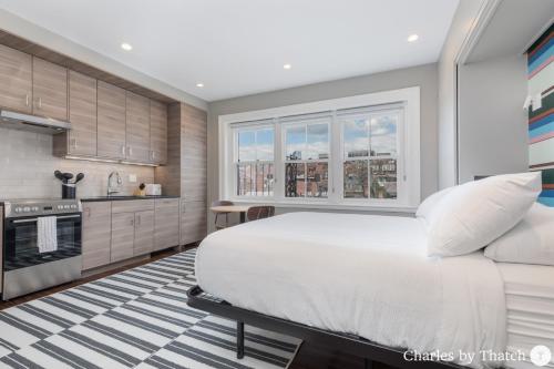 a bedroom with a large bed and a kitchen at J Miller Flats by Thatch in Boston