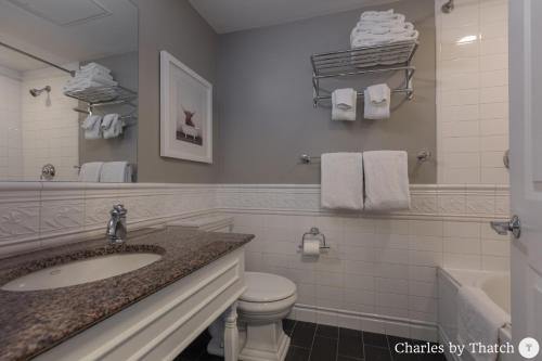 a bathroom with a sink and a toilet and a tub at 94 Charles Street by Thatch in Boston