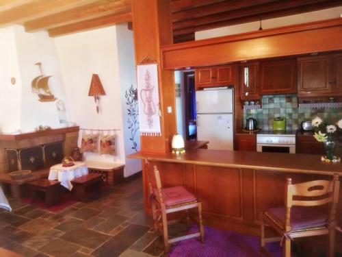 eine Küche mit einer Theke und einem Tisch in einem Zimmer in der Unterkunft Panoramic Views Home in Hydra, Greece in Hydra
