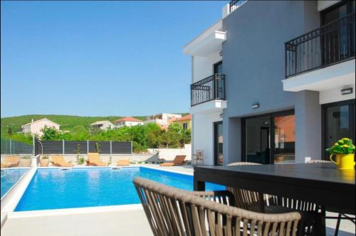a villa with a swimming pool and a table and chairs at Villa BO in Koprivno