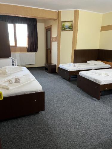 a room with three beds and a window at Hotel Monte Carlo in Piteşti