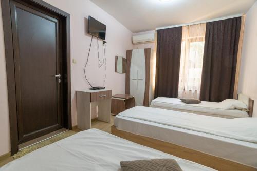 a hotel room with two beds and a window at Hotel Verona in Byala Ruse