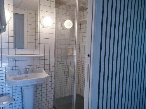a white bathroom with a sink and a shower at Le Moulin de Villiers in Gudmont