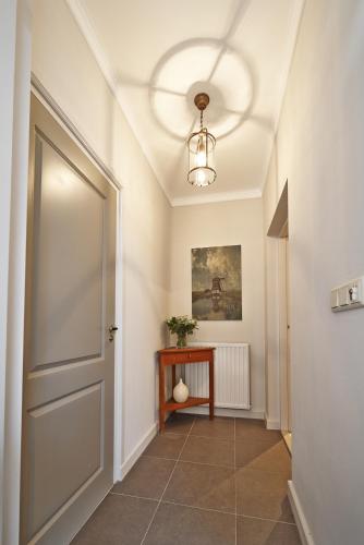 a hallway with a door and a table at Villa Magnolia in Oostkapelle