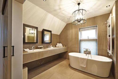 a large bathroom with two sinks and a tub at Villa Magnolia in Oostkapelle