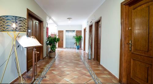 a hallway with a tile floor and a lamp at Hotel Doña Matilde in Estepona