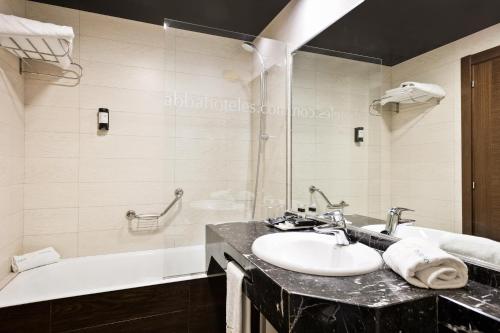 a bathroom with a sink and a tub at Abba Santander in Santander