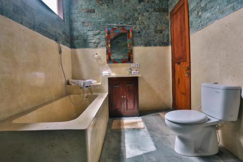 a bathroom with a tub and a toilet and a sink at Bali Ubud Villa View in Ubud