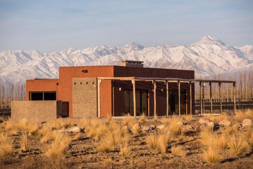a building in the desert with mountains in the background at Lodge Atamisque in San José