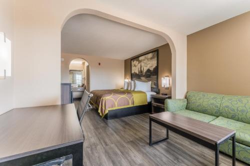 Habitación de hotel con cama y sofá en Super 8 by Wyndham Lake Charles Northeast en Lake Charles