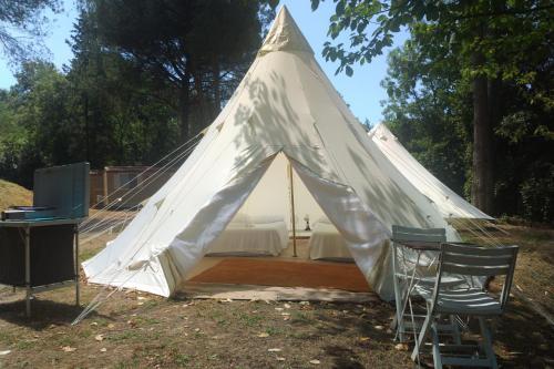 a white tent with two chairs and a table at Toscana Holiday Village in Montopoli in Val dʼArno