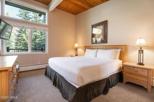 a bedroom with a large bed and two windows at Slopeside 2 Bedroom Gold-rated Residence At Golden Peak In Vail Village in Vail