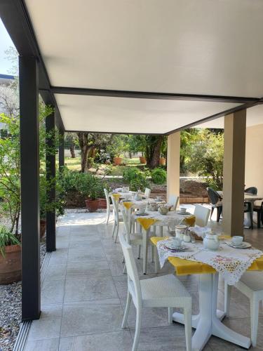 a row of tables and white chairs on a patio at Albergo Campagnola in Lazise