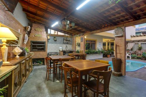 uma cozinha com mesas e cadeiras e uma piscina em Pousada Carolina em Florianópolis
