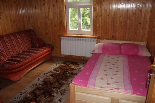 a bedroom with a bed and a couch at Eko-Sen in Białowieża