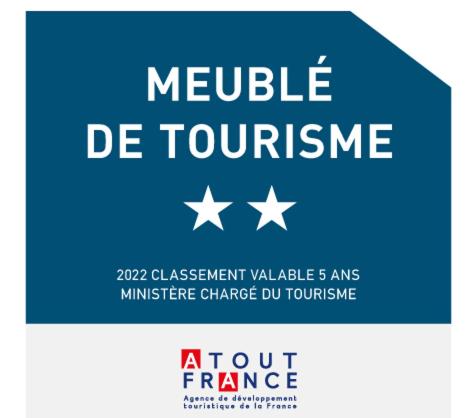 a blue sign with white stars and a module de tourism at Caraibe Créol' Keys in Port-Louis