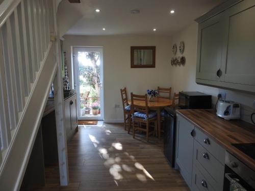 a kitchen with a table and a dining room at The Shed @ Stares Farm Cottage in Shedfield